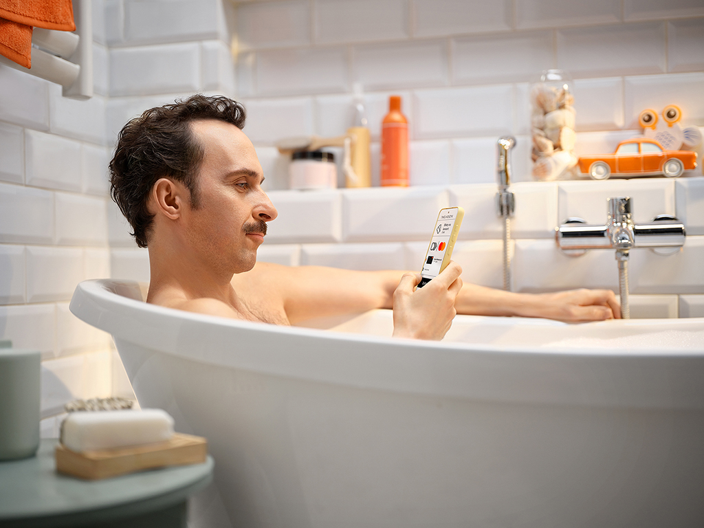 mężczyzna korzystający ze smartfona w wannie