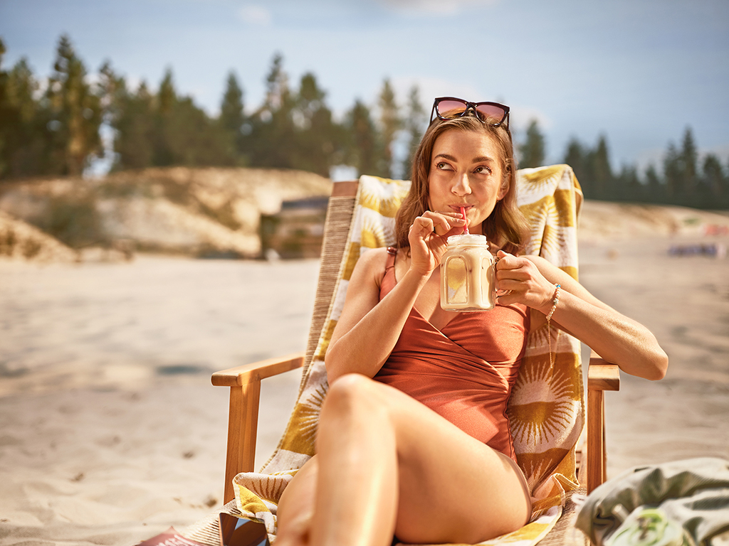 kobieta pijąca shake na plaży